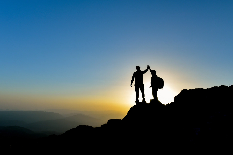 silhouettes of people on a mountaintop